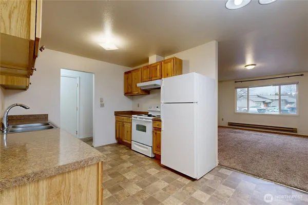 a kitchen with granite countertop a refrigerator and a stove