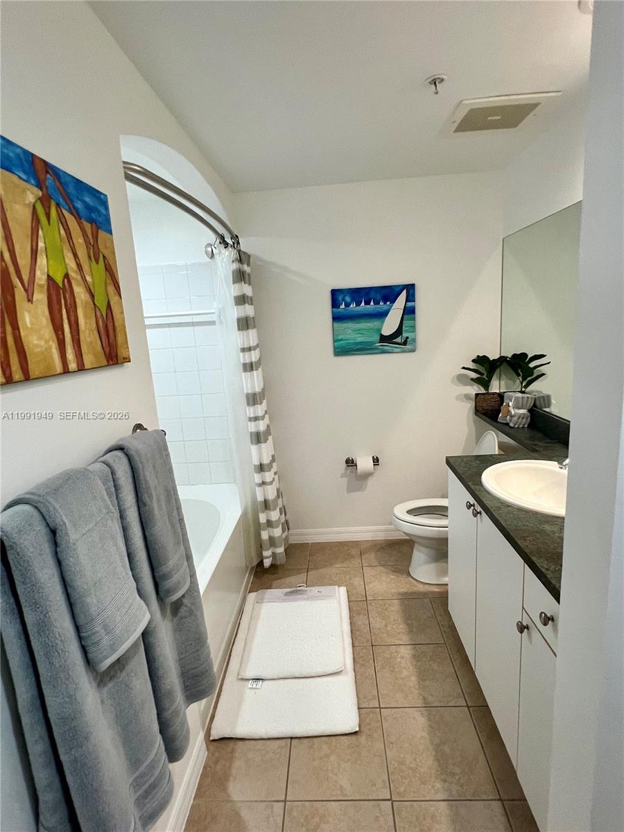 9172 Collins Avenue, Unit 305 Surfside, FL 33154 - Photo 11 of 37 a bathroom with a granite countertop sink a toilet a tub and shower