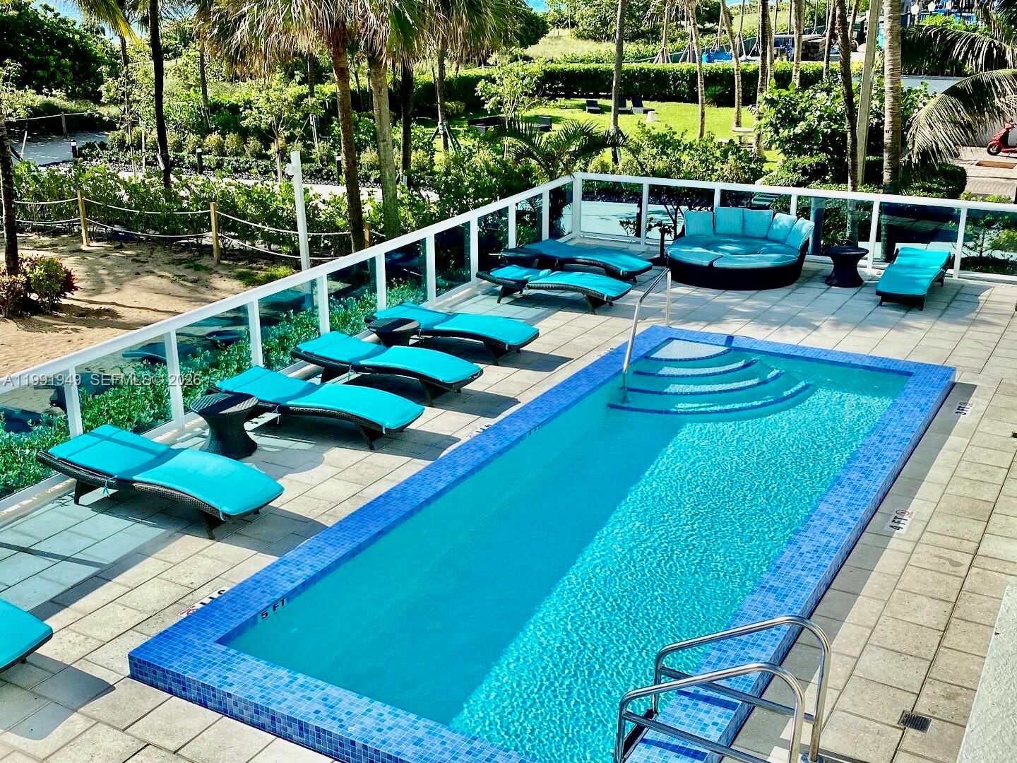 9172 Collins Avenue, Unit 305 Surfside, FL 33154 - Photo 20 of 37 a view of a backyard with lawn chairs and potted plants