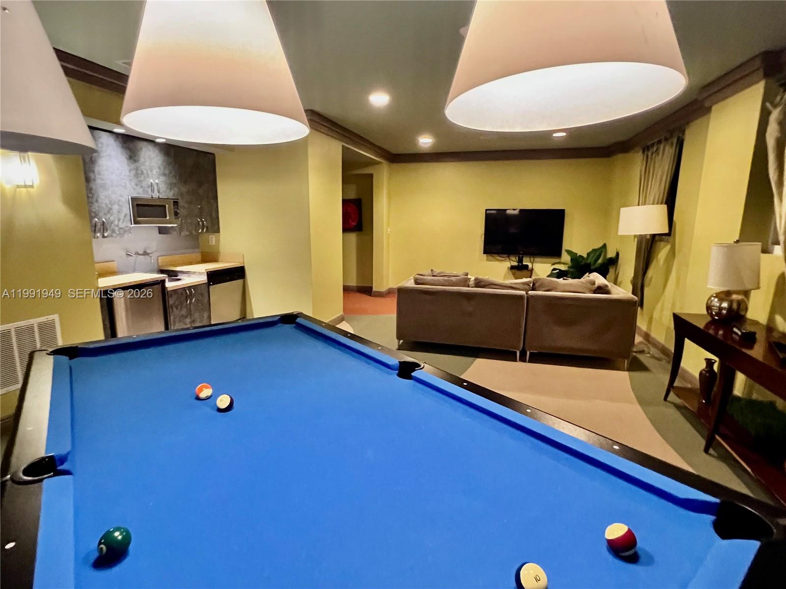 9172 Collins Avenue, Unit 305 Surfside, FL 33154 - Photo 24 of 37 a living room with furniture and a flat screen tv