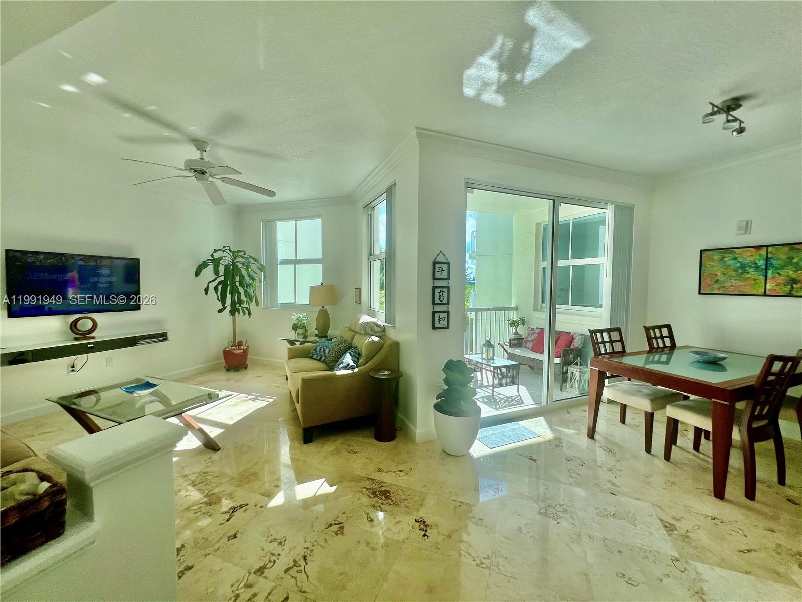 9172 Collins Avenue, Unit 305 Surfside, FL 33154 - Photo 3 of 37 a living room with furniture and a flat screen tv