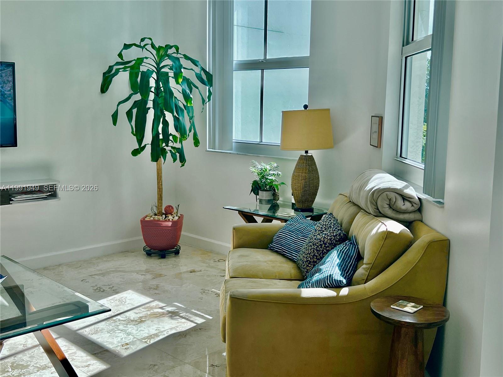 9172 Collins Avenue, Unit 305 Surfside, FL 33154 - Photo 4 of 37 a living room with furniture and potted plant