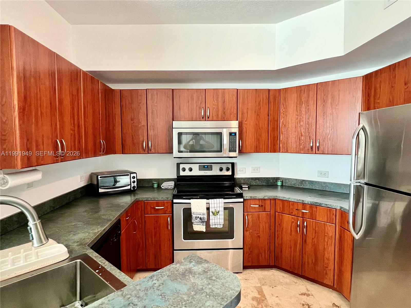 9172 Collins Avenue, Unit 305 Surfside, FL 33154 - Photo 7 of 37 a kitchen with a refrigerator stove and sink