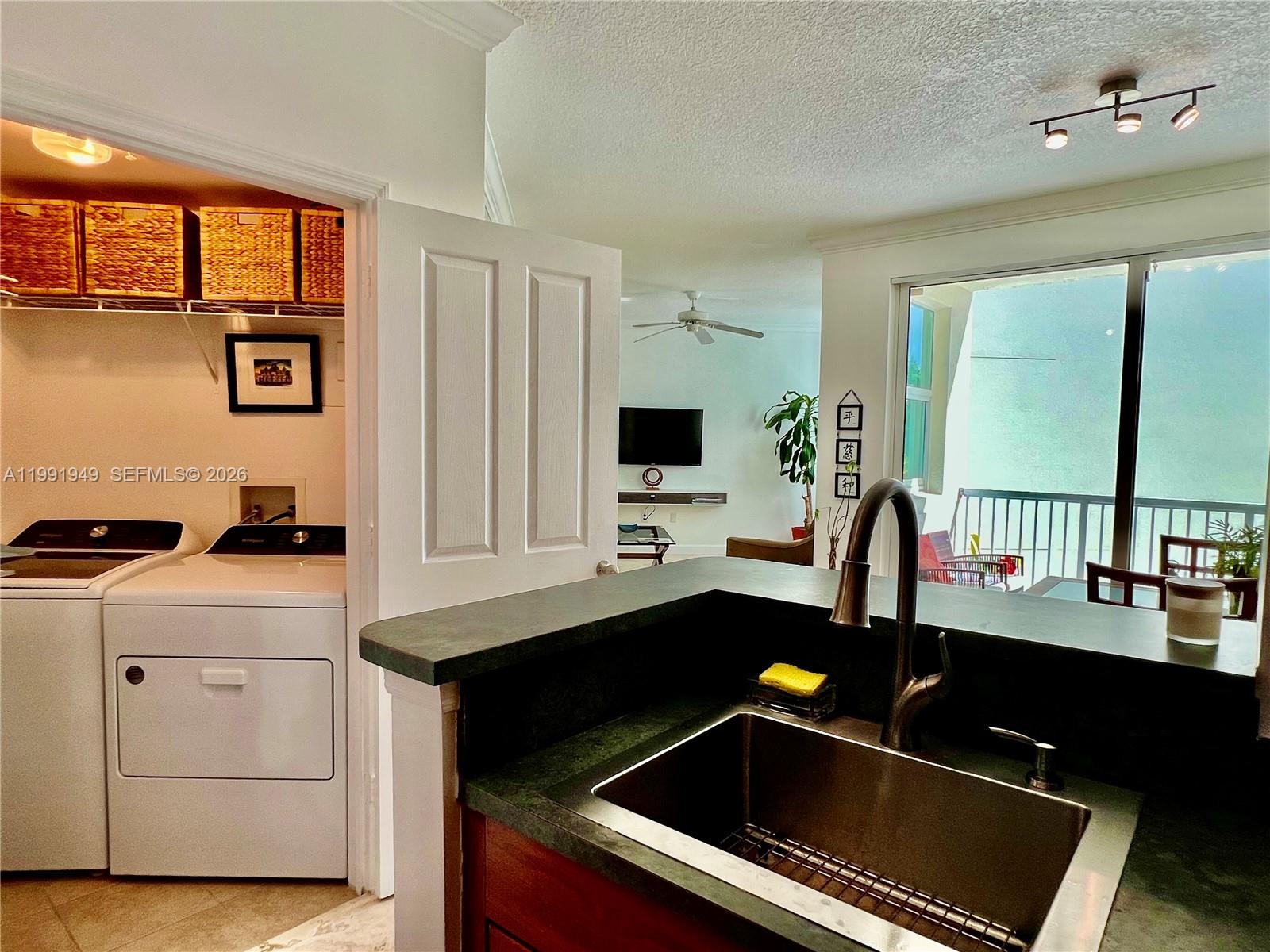9172 Collins Avenue, Unit 305 Surfside, FL 33154 - Photo 9 of 37 a kitchen with a sink cabinets and window