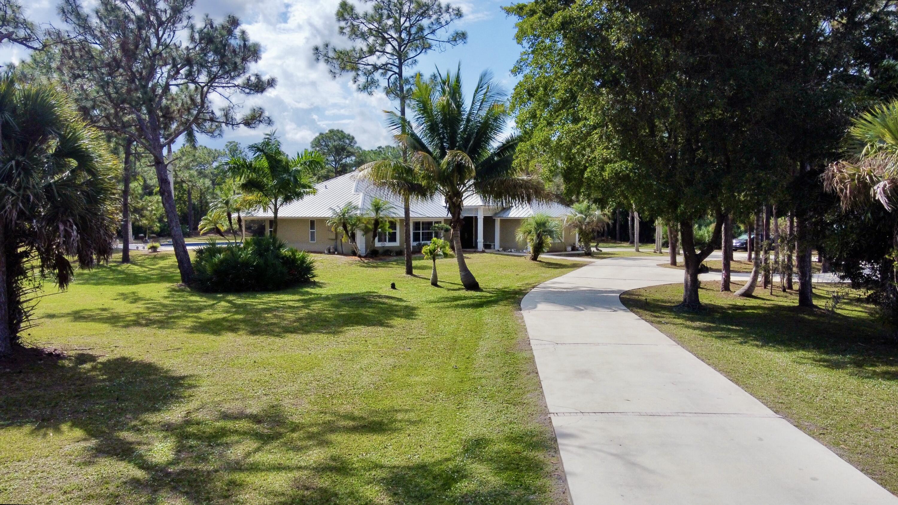 2884 Southeast Ranch Acres Circle Jupiter, FL 33478 - Photo 2 of 93 front with driveway
