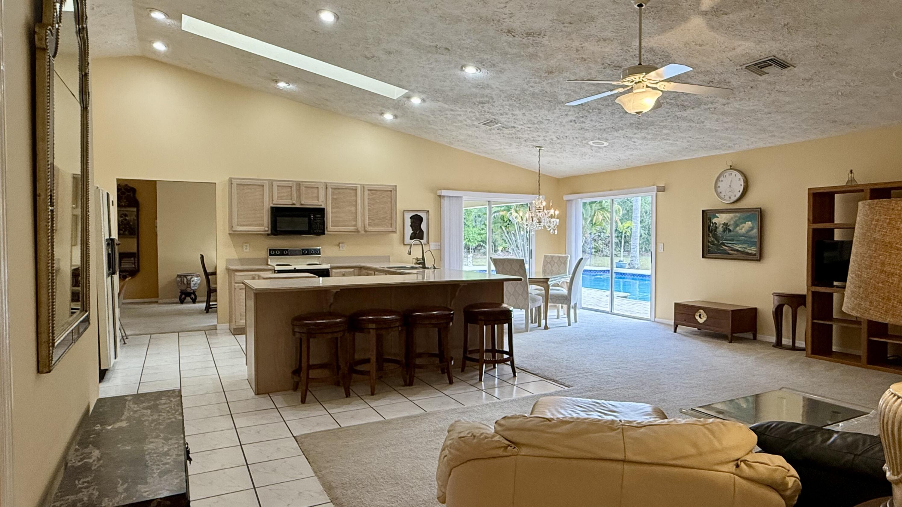 2884 Southeast Ranch Acres Circle Jupiter, FL 33478 - Photo 9 of 93 family room to kitchen