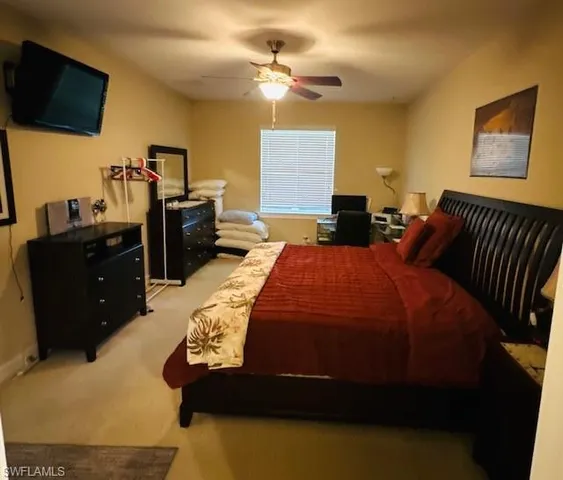 a bedroom with a bed dresser and flat screen tv