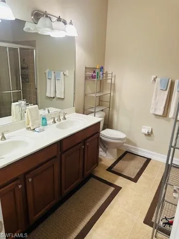 a bathroom with a double vanity sink mirror and toilet