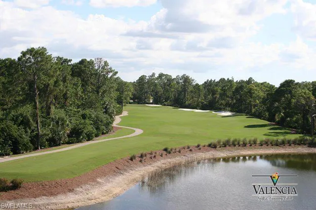 a view of a lake with a yard and large trees