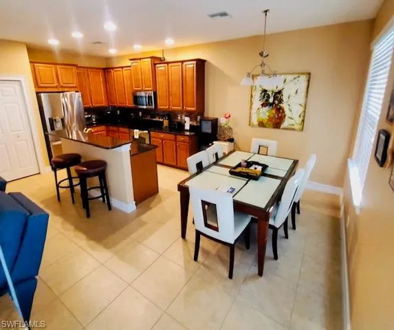 a dining room with furniture and a floor to ceiling window