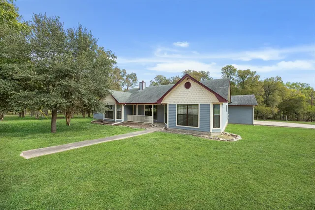 a front view of a house with a yard and trees