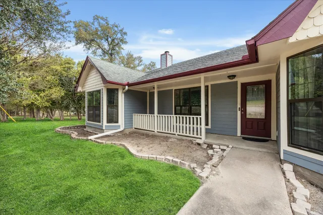 a view of a house with a yard and porch