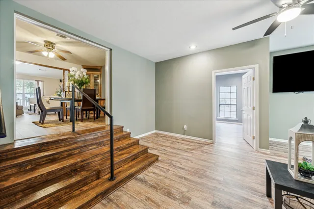 a view of a hallway with wooden floor and furniture