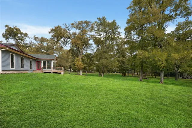 a view of a big yard with a house in the background