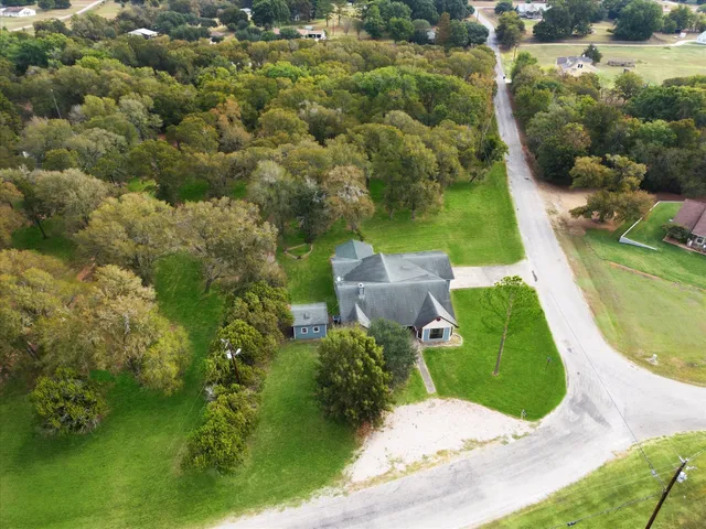 an aerial view of a house with a yard and lake view