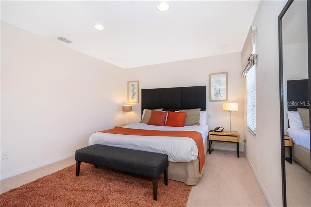 3007 White Orchid Road Kissimmee, FL 34747 - Photo 15 of 23 a bedroom with a bed a couch and a flat tv screen on the dresser