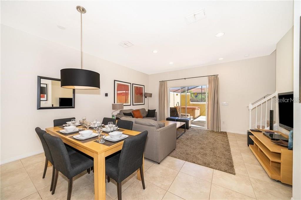 3007 White Orchid Road Kissimmee, FL 34747 - Photo 8 of 23 a living room with furniture a flat screen tv and a dining table