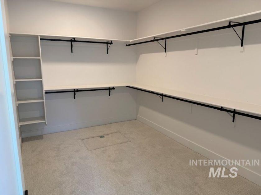 755 West Wrangler Street Meridian, ID 83646 - Photo 12 of 35 The master bedroom boasts spacious closet featuring white walls, light-toned carpeting, ample shelving, and black hanging rods