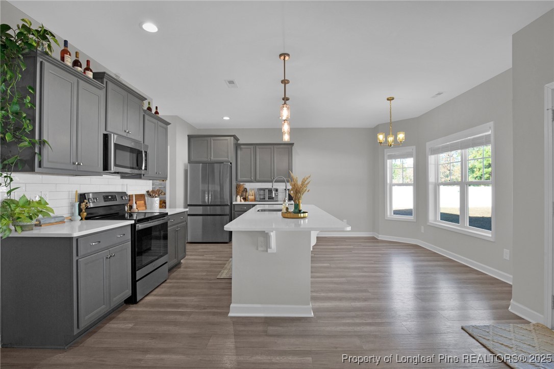 248 Rainy Beck Way Erwin, NC 28339 - Photo 11 of 44 a kitchen with kitchen island granite countertop a stove top oven a sink dishwasher a dining table and chairs with wooden floor