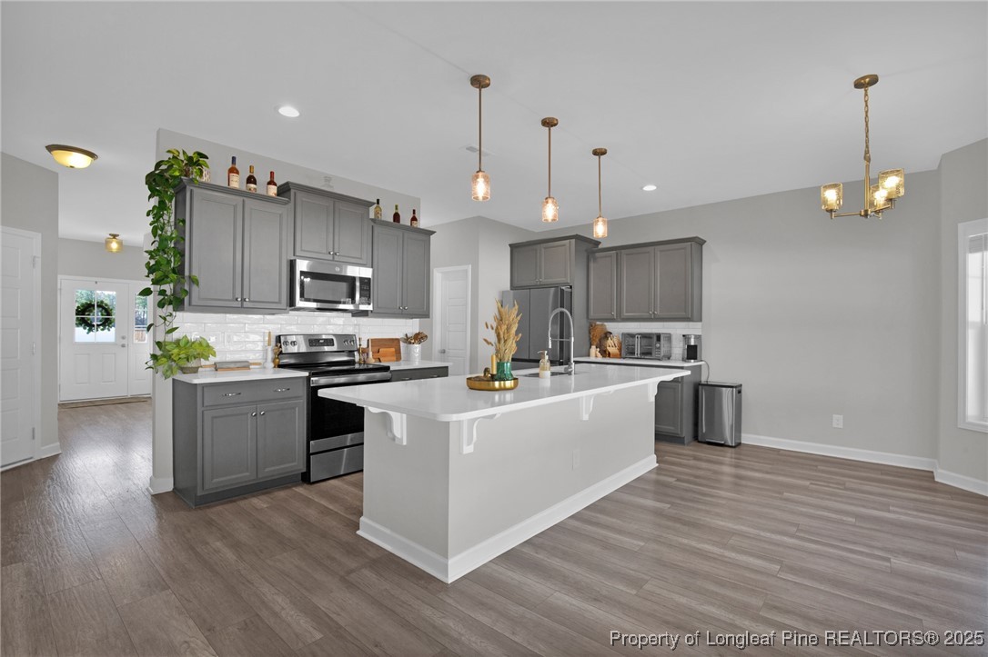 248 Rainy Beck Way Erwin, NC 28339 - Photo 12 of 44 a kitchen with kitchen island white cabinets and stainless steel appliances