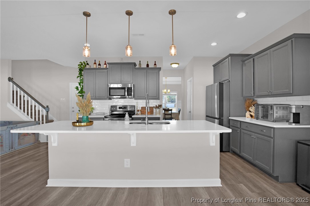 248 Rainy Beck Way Erwin, NC 28339 - Photo 13 of 44 a view of a kitchen with kitchen island stainless steel appliances a center island a stove a refrigerator cabinets and living room view