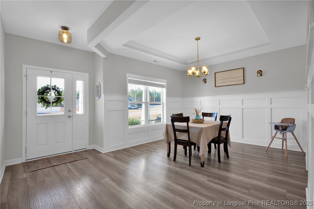248 Rainy Beck Way Erwin, NC 28339 - Photo 5 of 44 a dining room with wooden floor a chandelier a wooden table and chairs