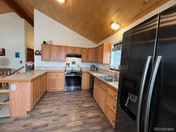 a kitchen with stainless steel appliances granite countertop a stove top oven a sink and dishwasher
