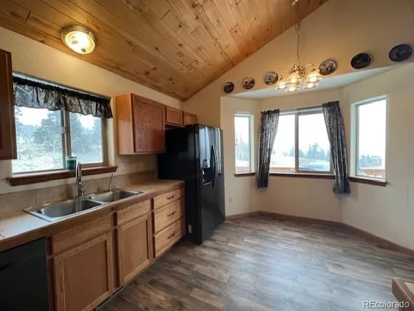 a kitchen with sink a window and refrigerator