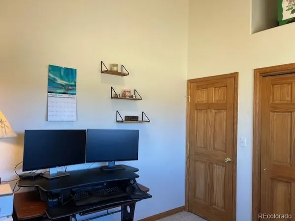 a view of a workspace with furniture and a window