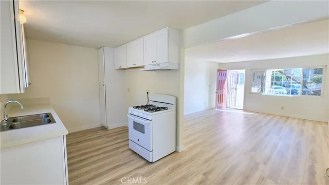a kitchen with white cabinets and sink
