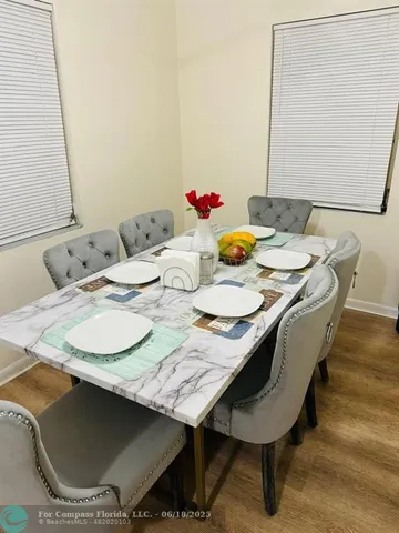 a dining room with furniture and wooden floor