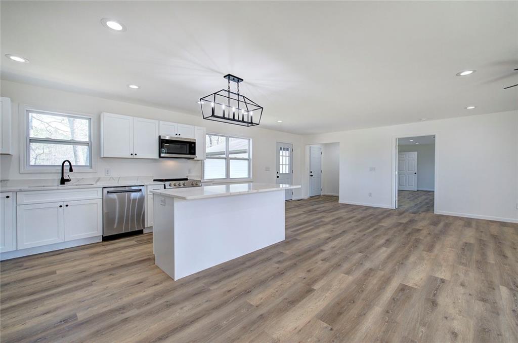 516 Baxter Road Southeast Calhoun, GA 30701 - Photo 12 of 47 a kitchen with stainless steel appliances granite countertop a stove top oven a sink dishwasher and a refrigerator with wooden floor