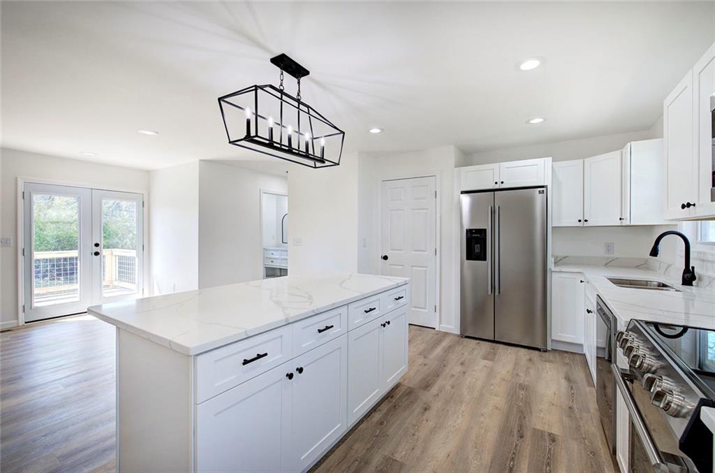 516 Baxter Road Southeast Calhoun, GA 30701 - Photo 13 of 47 a kitchen with a refrigerator a sink and dishwasher with wooden floor