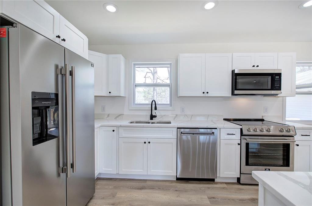 516 Baxter Road Southeast Calhoun, GA 30701 - Photo 14 of 47 a kitchen with stainless steel appliances a stove a sink and a refrigerator