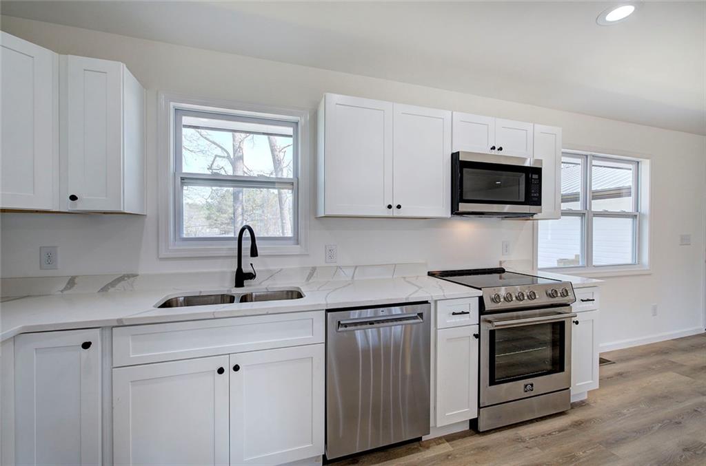 516 Baxter Road Southeast Calhoun, GA 30701 - Photo 16 of 47 a kitchen with white cabinets and a stove top oven