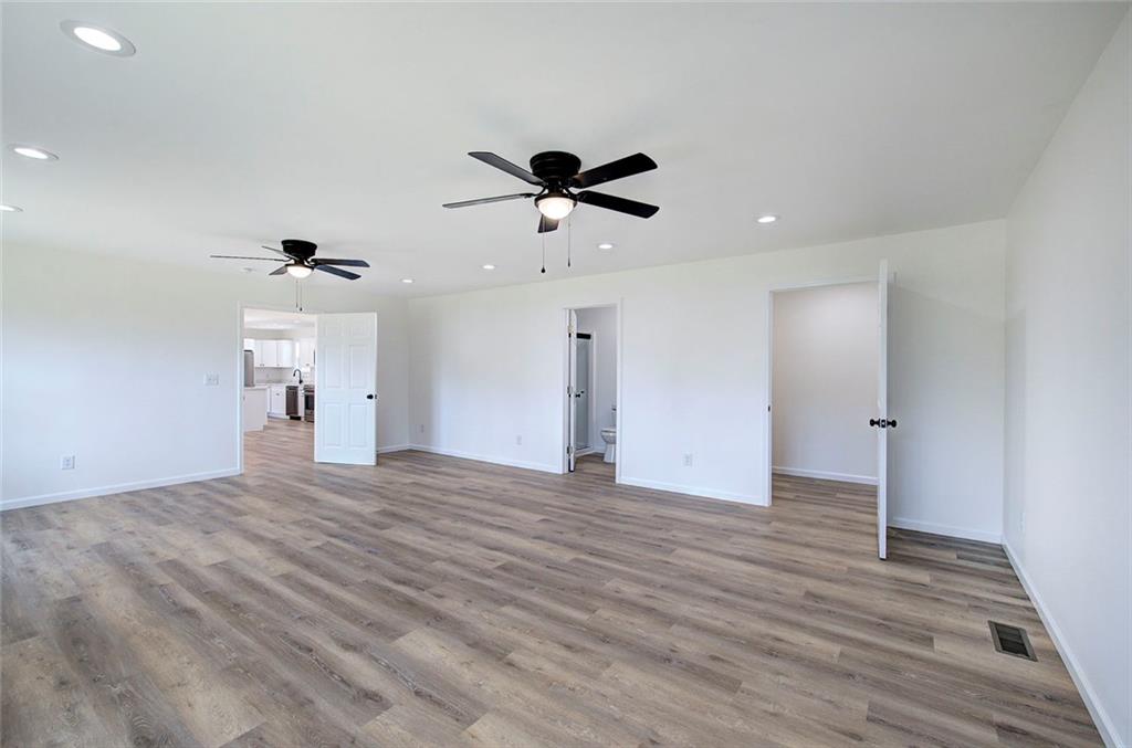 516 Baxter Road Southeast Calhoun, GA 30701 - Photo 25 of 47 a view of a kitchen with wooden floor and a ceiling fan