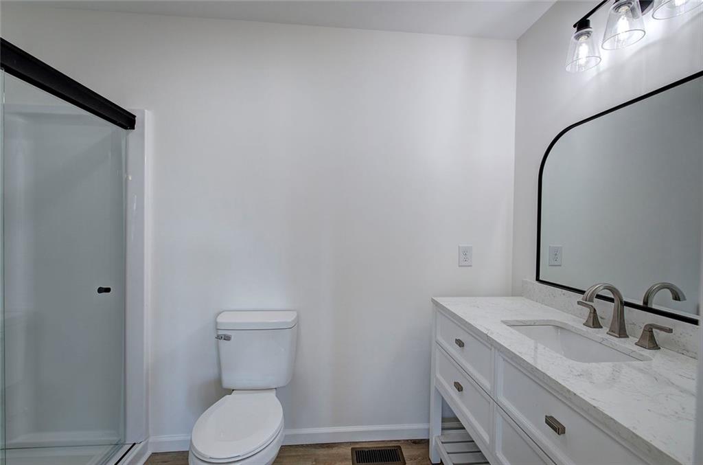 516 Baxter Road Southeast Calhoun, GA 30701 - Photo 26 of 47 a bathroom with a granite countertop sink toilet and a mirror