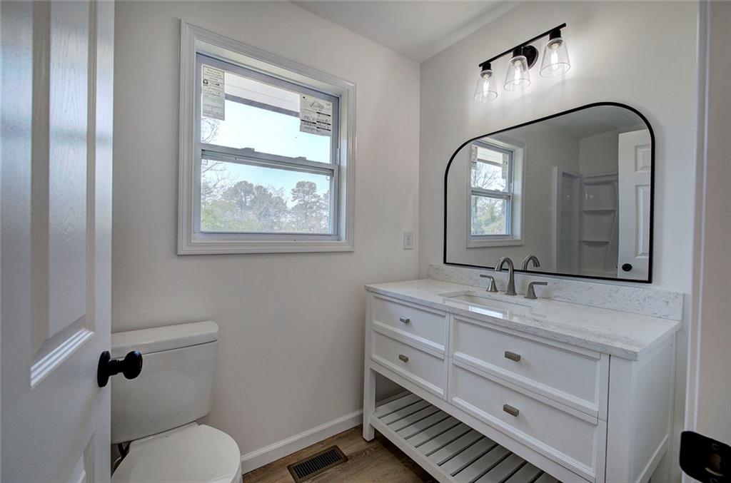 516 Baxter Road Southeast Calhoun, GA 30701 - Photo 31 of 47 a bathroom with a granite countertop toilet a sink and mirror