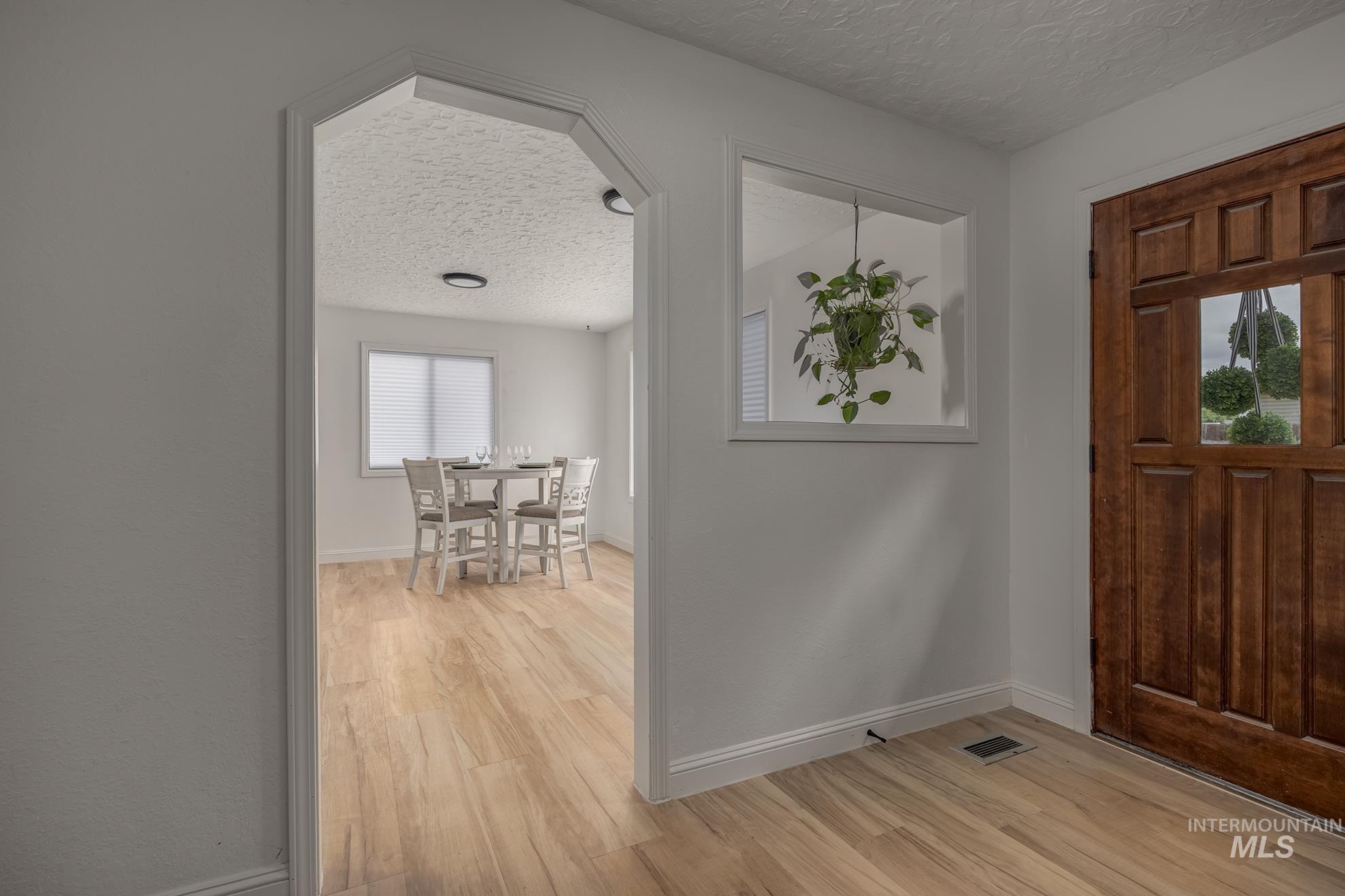 61 Southwest 4th Street Ontario, OR 97914 - Photo 5 of 42 Archway entry featuring wood-finish flooring, a solid wood entry door, and a rectangular interior window