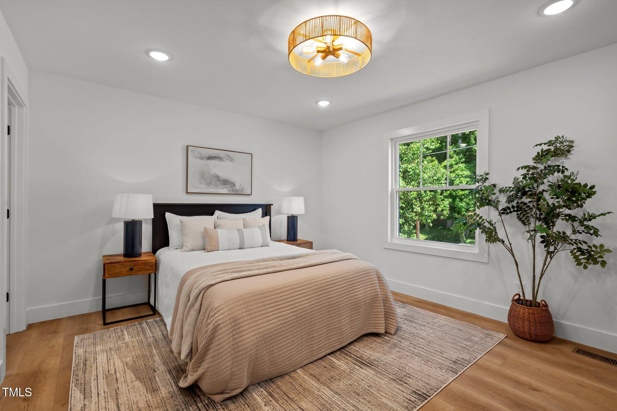 2801 Ashland Street Raleigh, NC 27608 - Photo 21 of 44 a bedroom with a bed and a potted plant