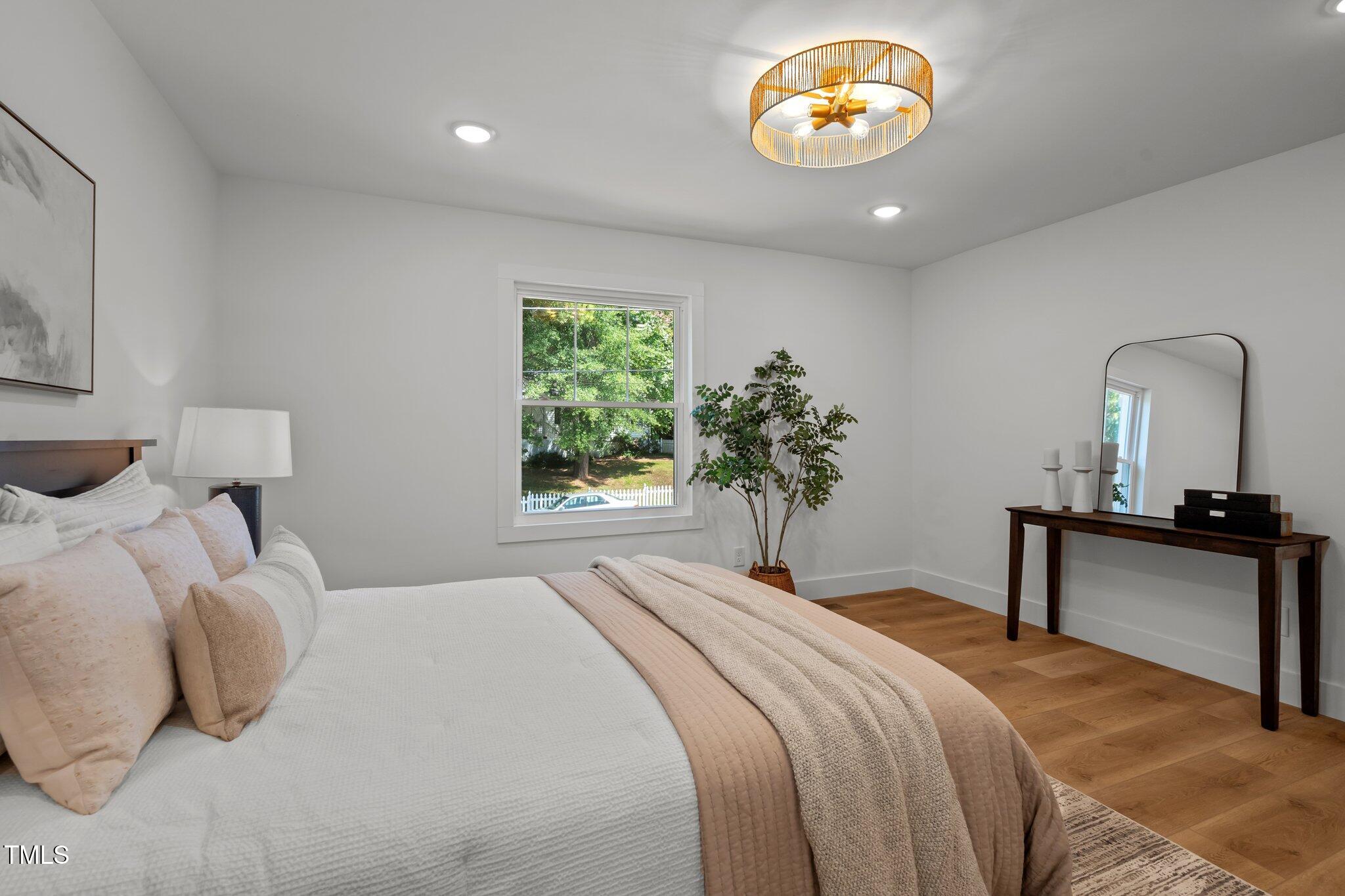 2801 Ashland Street Raleigh, NC 27608 - Photo 22 of 44 a bedroom with a bed and a potted plant