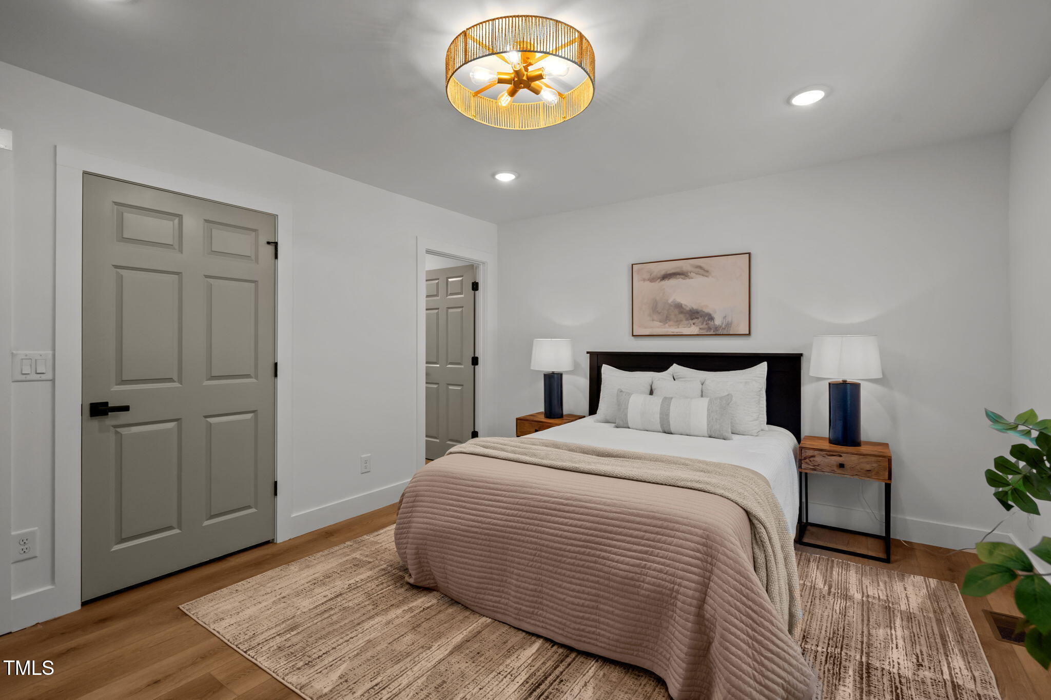 2801 Ashland Street Raleigh, NC 27608 - Photo 23 of 44 a bedroom with a large bed and a chandelier