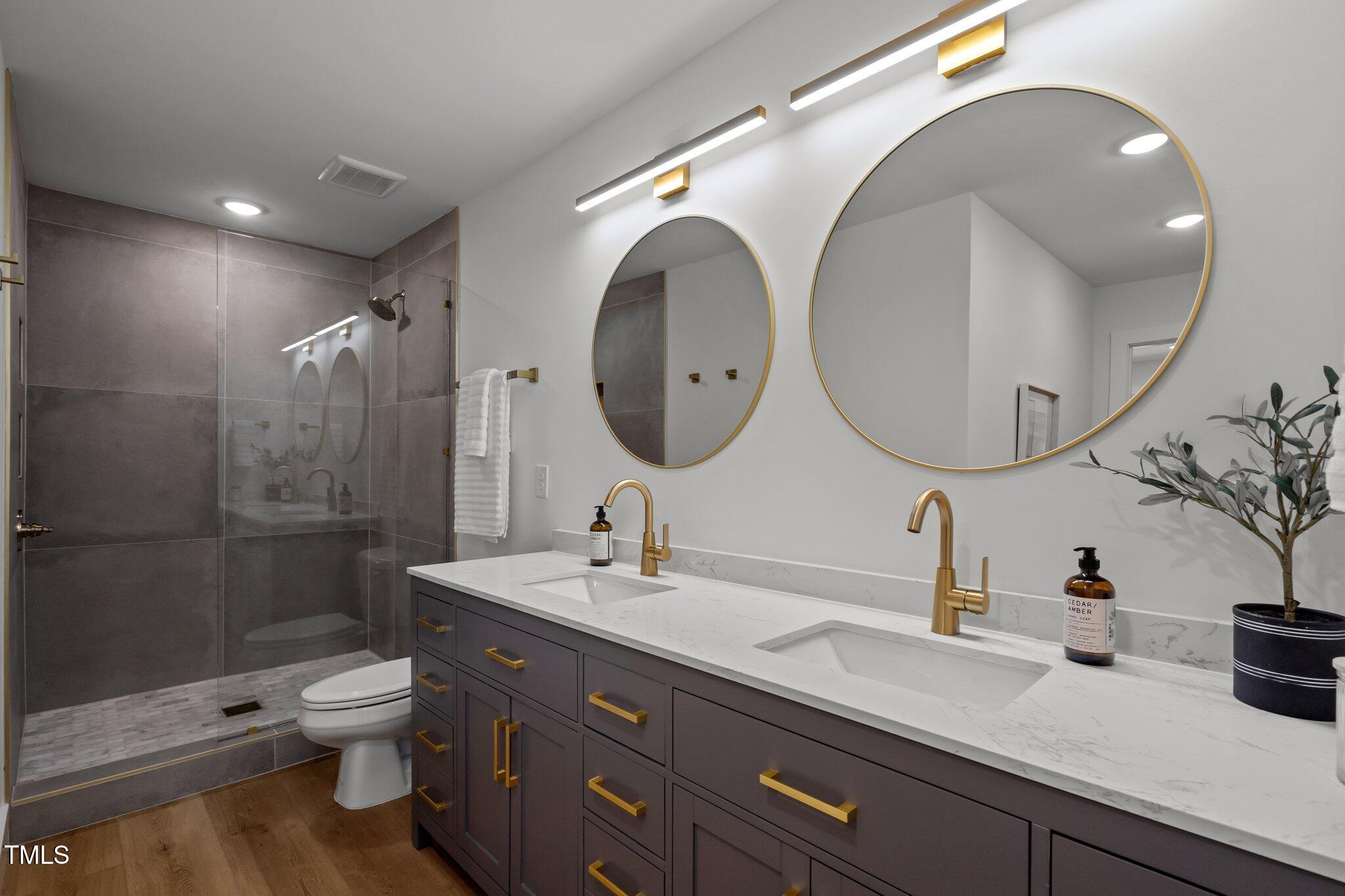 2801 Ashland Street Raleigh, NC 27608 - Photo 24 of 44 a bathroom with a double vanity sink toilet mirror and shower