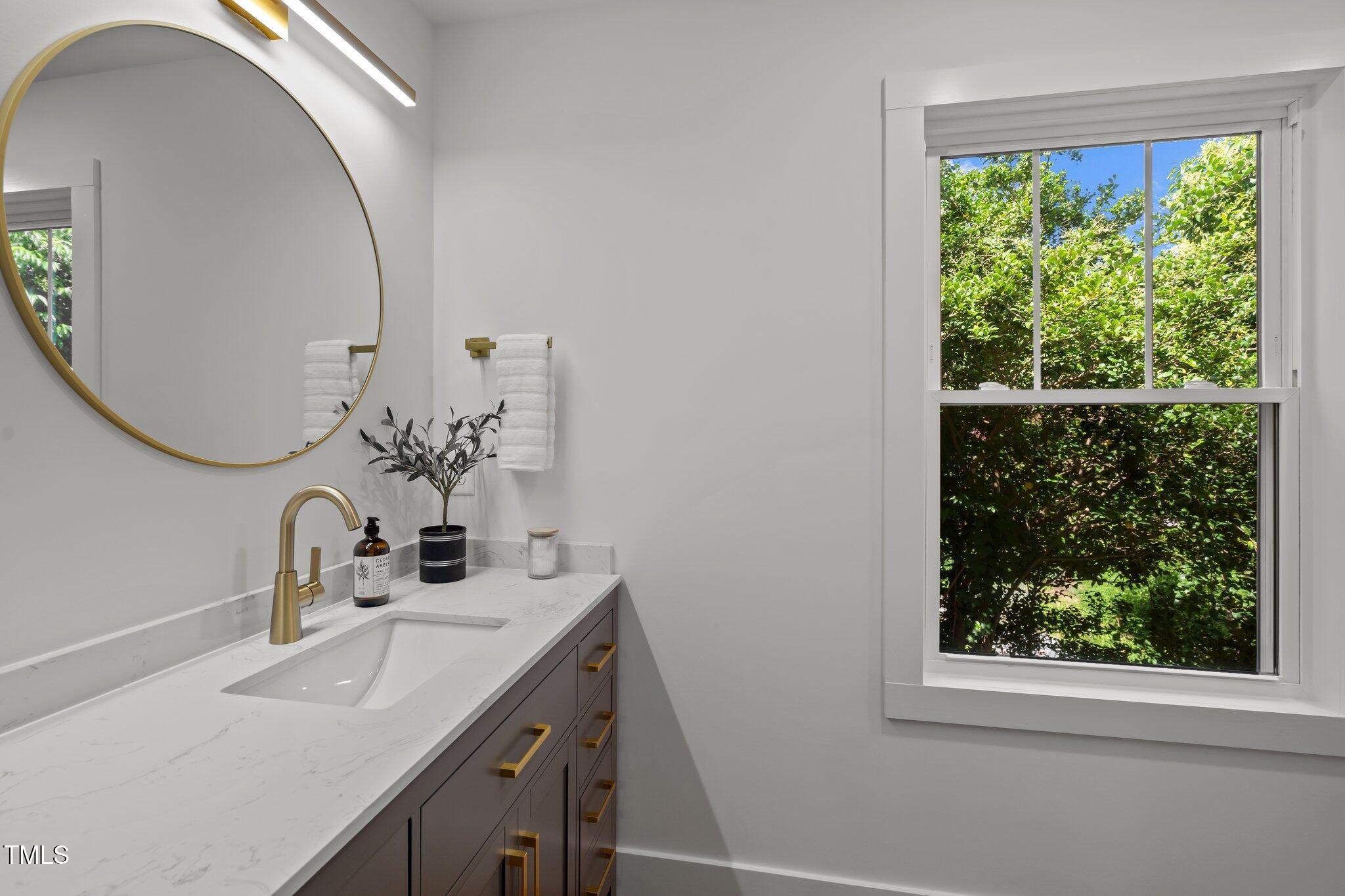 2801 Ashland Street Raleigh, NC 27608 - Photo 25 of 44 a bathroom with a sink and a mirror