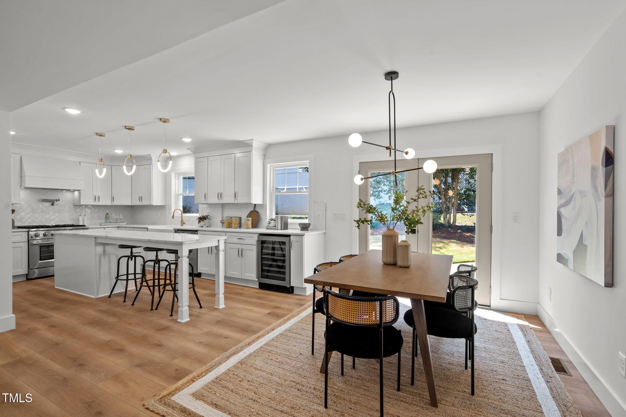 2801 Ashland Street Raleigh, NC 27608 - Photo 9 of 44 a kitchen with kitchen island a dining table chairs stainless steel appliances and cabinets