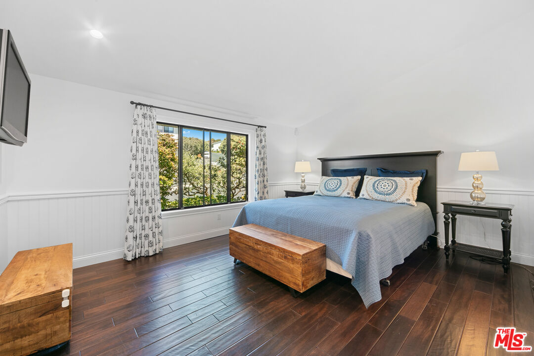 6801 Shearwater Lane Malibu, CA 90265 - Photo 15 of 33 a spacious bedroom with a bed and wooden floor