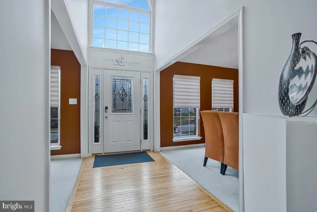 a view of a hallway with wooden floor and windows