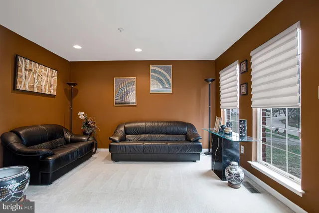 a living room with furniture ceiling fan and a window