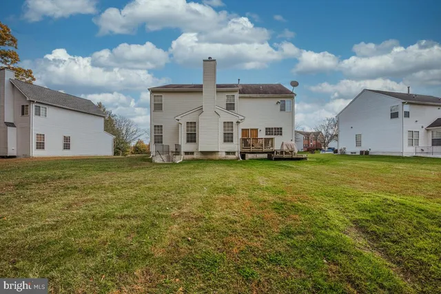 a big white house with a big yard and large trees