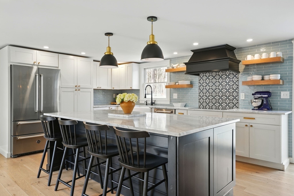 a kitchen with a table chairs refrigerator and cabinets